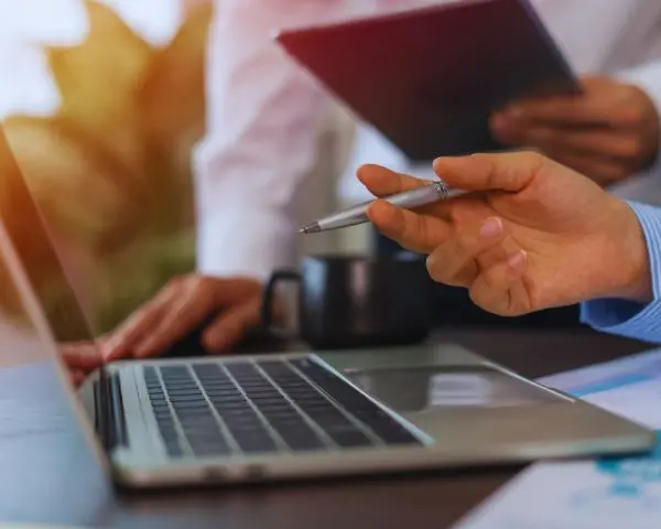 imagen en donde se ven dos personas que manipulan un computador portatil y una tableta en donde visualizan los expedientes judiciales de manera virtual